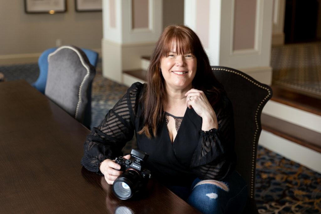 Boudoir photographer, Meg Wallace, posing with camera at Shutterfest Photography conference